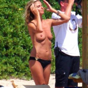 Heidi Klum adjusting her hair and with no top on